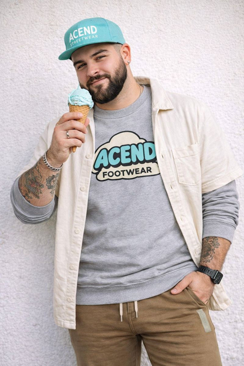 Original archive portrait with teal ACEND cap, grey ACEND Footwear crewneck, cream overshirt, tan pants and an ice cream cone